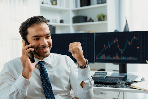 Comerciante exitoso hombre de negocios levantando el puño llamando por teléfono Surmise