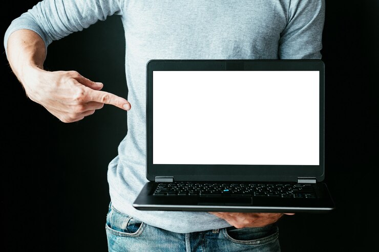 Foto comercio electrónico y comercio electrónico. marketing digital online. ganar dinero en internet. hombre apuntando con el dedo a la pantalla vacía del portátil blanco.