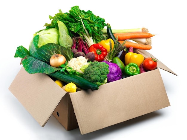 Comestibles y verduras de estudio en caja con ingredientes de alimentos orgánicos y productos sobre fondo blanco Cosecha de nutrición y recipiente con productos para la sostenibilidad y el bienestar del estilo de vida vegano