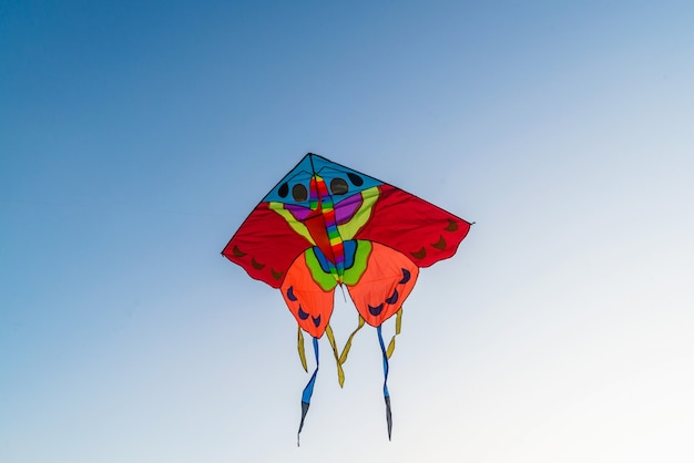 Cometa de colores brillantes volando en el cielo azul claro