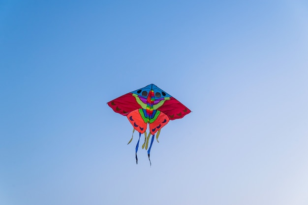 Cometa de colores brillantes volando en el cielo azul claro