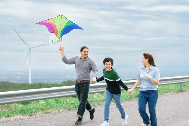 Cometa voladora de concepto de vacaciones familiares despreocupadas felices progresivas con turbina eólica