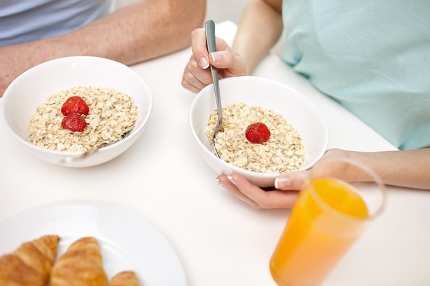 Foto comida, alimentação, pessoas e conceito de comida saudável - close-up de casal tomando café da manhã em casa