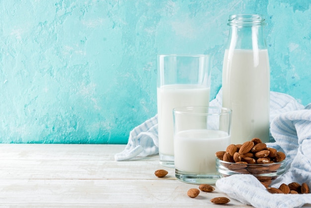 Comida alternativa vegana, leche de almendras no láctea sobre fondo azul claro, espacio de copia