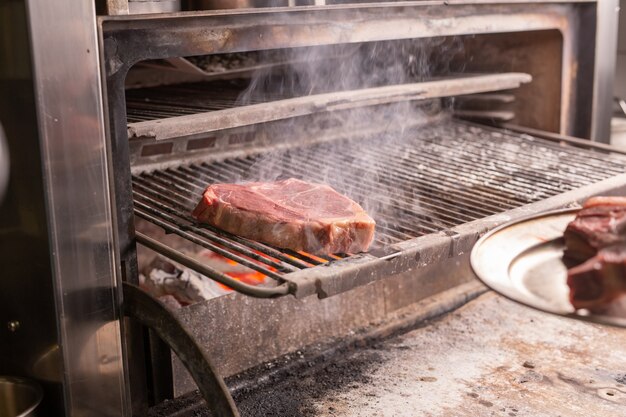 Comida, artesanía y concepto delicioso: cocinar bistec a la parrilla.