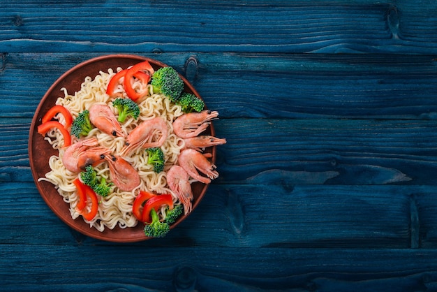 Comida asiática com frutos do mar e legumes. camarão, brócolis, páprica, especiarias. vista do topo. espaço livre para texto.