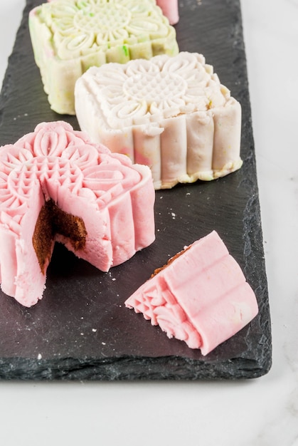 Comida asiática, japonesa, postre dulce tradicional multicolor sin hornear pasteles de luna de piel de nieve en la mesa de mármol blanco.