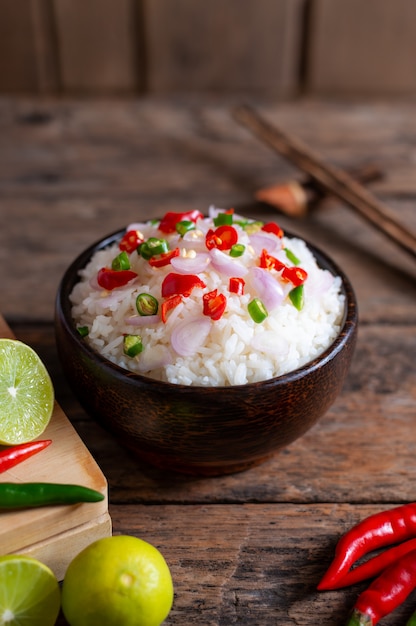 Comida asiática picante de arroz de cejas con verduras y chopstic en madera