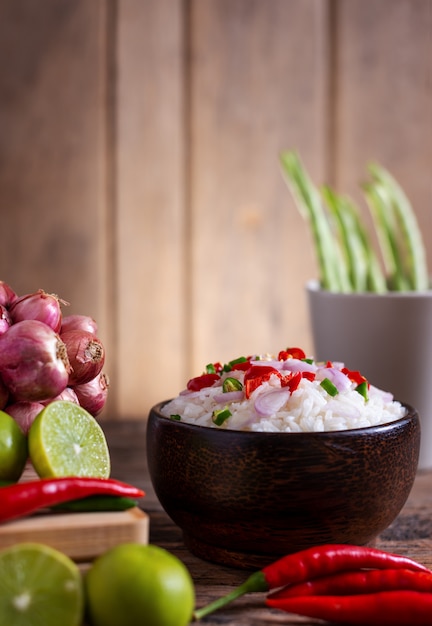 Comida asiática picante de arroz de cejas con verduras y chopstic en madera