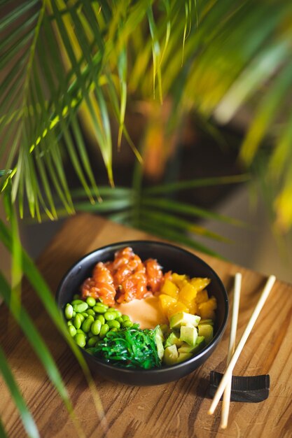 Comida asiática. Tigela com salmão, abacate, ervilhas e algas. Fotografia de comida