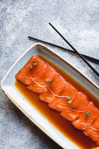 Comida asiática. Trozos de salmón con salsa picante y pimienta