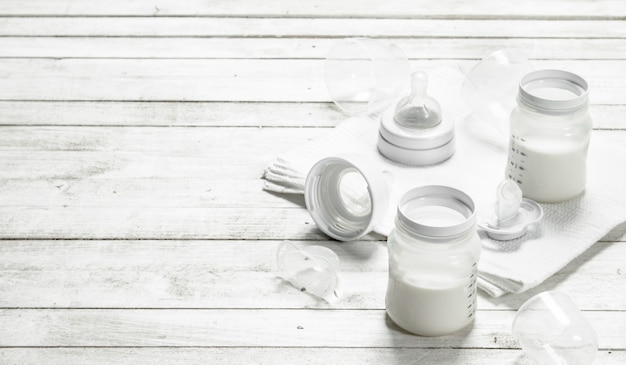 Comida para bebé. Leche para bebés en biberón. Sobre una mesa de madera blanca.