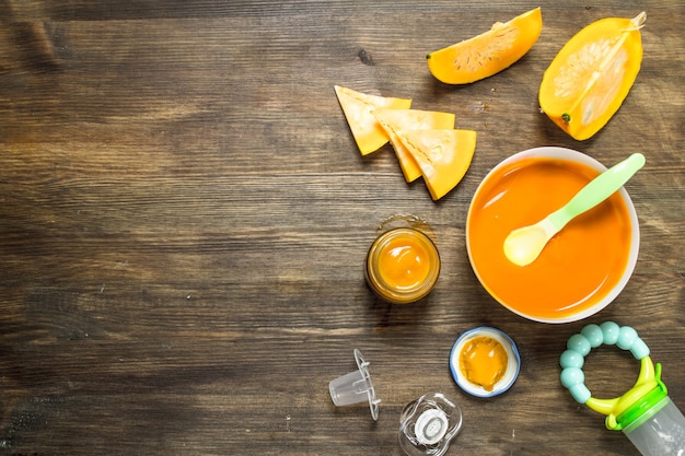 Comida para bebé. Puré de bebé de calabaza fresca. Sobre una mesa de madera.