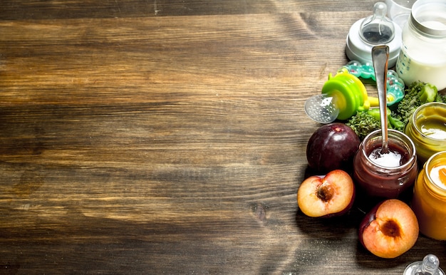 Comida para bebé. Variedad de purés de frutas y verduras para bebés. Sobre un fondo de madera.