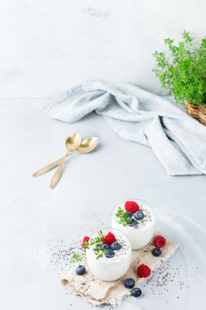 Comida y bebida concepto de alimentación y dieta saludable Pudín de chía blanco casero con bayas frescas y tomillo verde para el desayuno en una acogedora mesa de cocina Fondo del espacio de copia