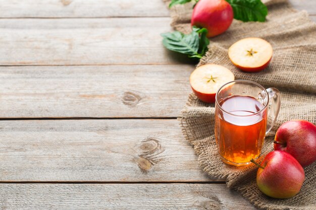 Comida y bebida, concepto de cosecha otoño otoño. Jugo de manzana orgánico fresco en una taza con frutas maduras sobre fondo de madera rústica. Copia espacio