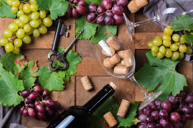 Comida y bebida cosecha otoño otoño concepto Cata de vinos degustación tarjeta de invitación con símbolos botella de vid de uva vasos sacacorchos Fondo de madera