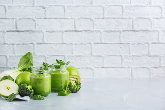 Comida y bebida, dieta y nutrición saludables, estilo de vida, vegano, alcalino, concepto vegetariano. Batido verde con ingredientes orgánicos, verduras en una mesa de cocina moderna. Copiar el fondo del espacio