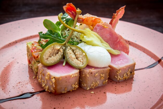 Comida bonita: bife de atum com gergelim, limão e close-up de salada fresca em um prato na mesa.