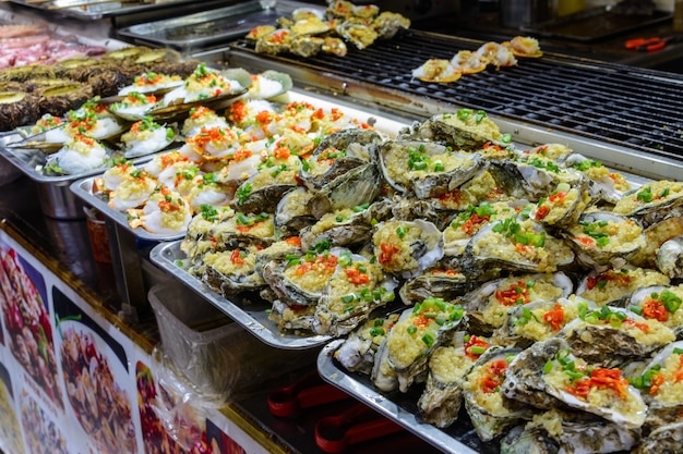 Comida callejera china. Comercio callejero. Tipos chinos de mariscos frescos en un mercado asiático de mariscos en Sanya, provincia de Hainan, China. Inscripción: nombre de la comida.