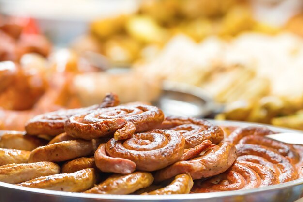 Comida callejera de la cocina tradicional asiática con verduras, carne y salchichas en el mercado