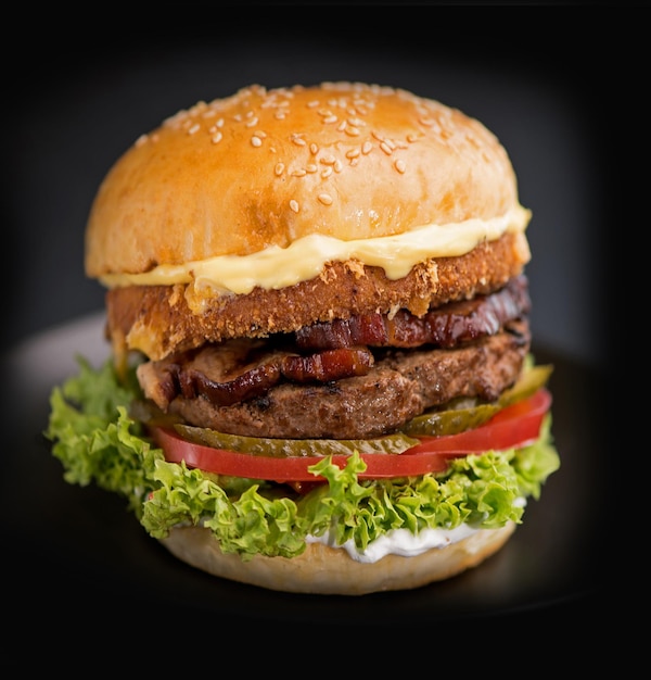 Comida callejera comida rápida Hamburguesas jugosas caseras con queso de res y cebollas sobre un fondo negro