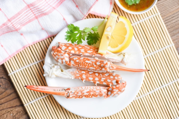 Comida de cangrejo hervida en un plato blanco y salsa de mariscos en la mesa