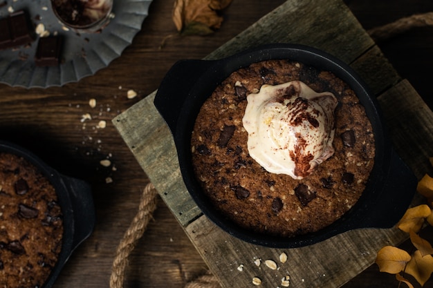 Comida caseira caseira, biscoito em frigideira gigante com gotas de chocolate e sorvete, vista de cima