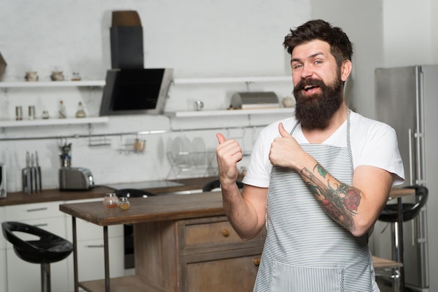 Comida caseira Recomendar boa receita Negócios culinários Chef confiante brutal no restaurante Chef masculino barbudo hipster cozinhando comida na cozinha Cozinha para homens de verdade Cozinhando comida saborosa em casa