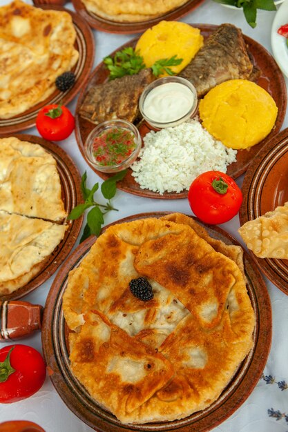 Comida casera rumana con pescado a la parrilla pasteles de polenta verduras con rojo win