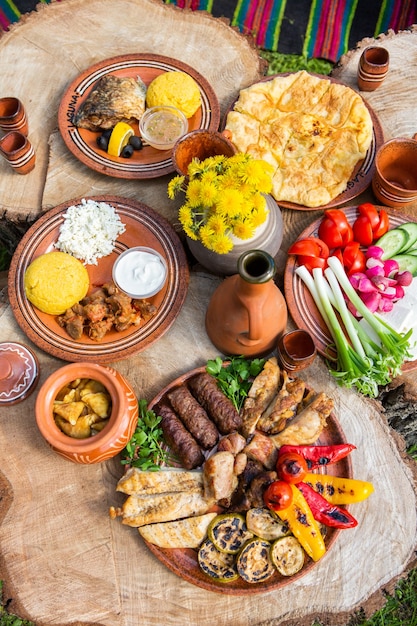 Comida casera rumana con polenta de carne a la parrilla y plato de verduras en camping