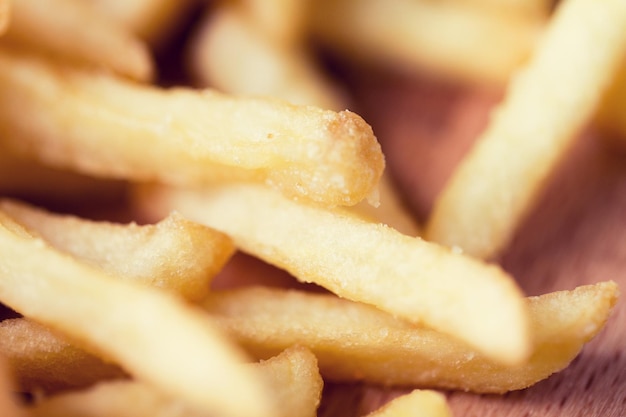 comida chatarra, comida rápida y concepto de comer - cerca de papas fritas en la mesa