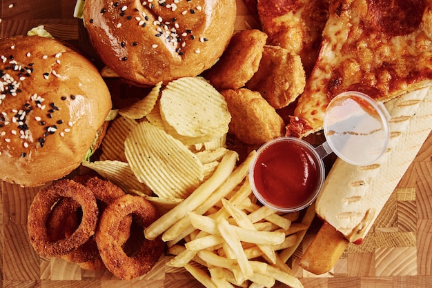 Comida chatarra y poco saludable. Diferentes tipos de comida rápida en la mesa, cerrar