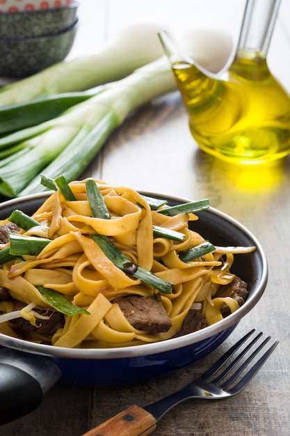 Comida china de carne de res Chow Mein en sartén sobre mesa de madera sobre mesa de madera