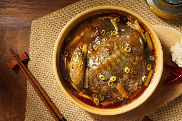 Comida chinesa especial Tartaruga de casca mole refogada com cebolinha em um fundo vintage escuro