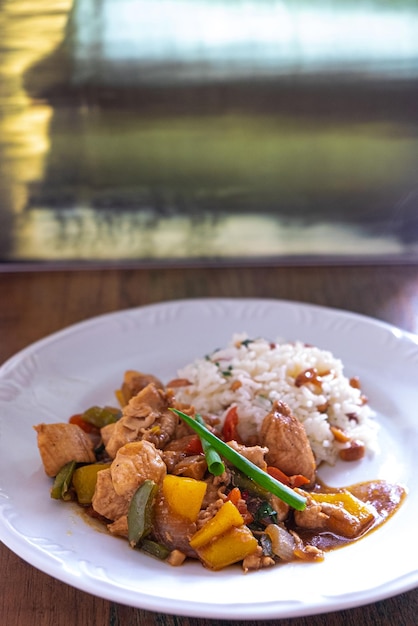 Comida chinesa típica de frango quadriculada servida com frango e pimentão, amendoim e arroz