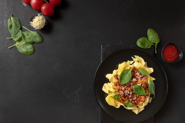 Comida clásica en pasta italiana con salsa boloñesa en un plato negro