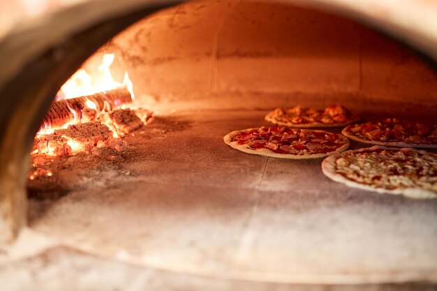 comida, cocina italiana y concepto de cocina: pizza horneada en horno en pizzería