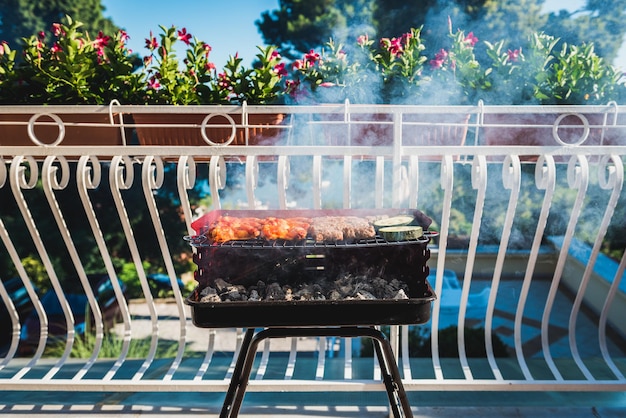 Foto la comida se cocina en la parrilla de la barbacoa en el balcón