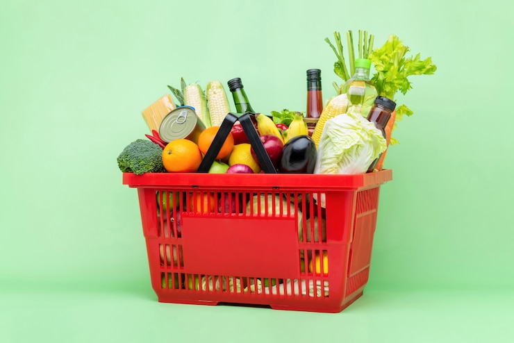 Foto comida colorida y comestibles en cesta de plástico de supermercado rojo