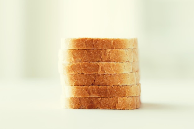 comida, comida chatarra y concepto de alimentación poco saludable - primer plano de la pila de pan tostado en rodajas blancas sobre la mesa