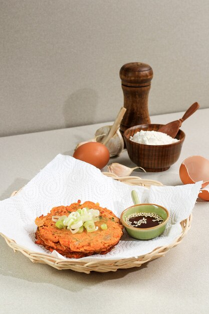 Comida coreana: Panqueca coreana Kimchi Jeon. Ovo frito em frigideira, Kimchi e farinha. Servido em prato de vime com espaço para texto