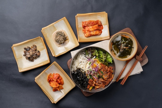 comida coreana pasta de soja estofado carne de cerdo picante bibimbap guarniciones verduras kimchi olla de barro