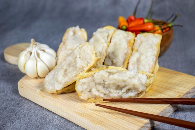 Foto comida da indonésia chamada tahu bakso ou almôndega dentro de tofu servido em uma placa de madeira