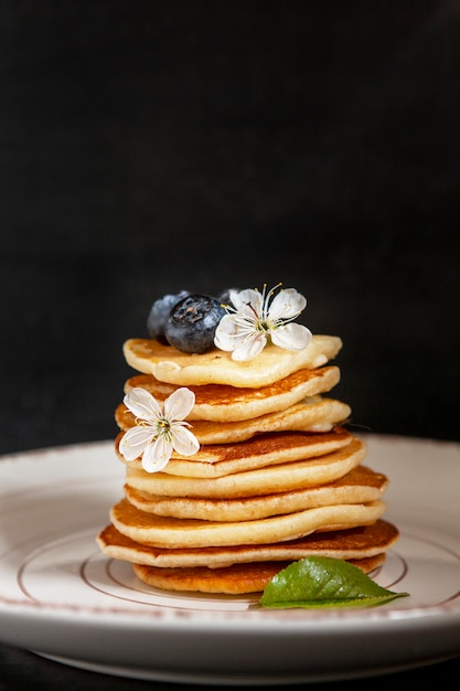 Comida da moda - pequenas panquecas. Poffertjes, pequenas panquecas holandesas. Café da manhã para crianças