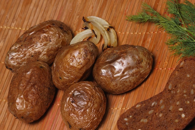 Comida de aldeia. Batatas caseiras com pão na mesa de madeira rústica