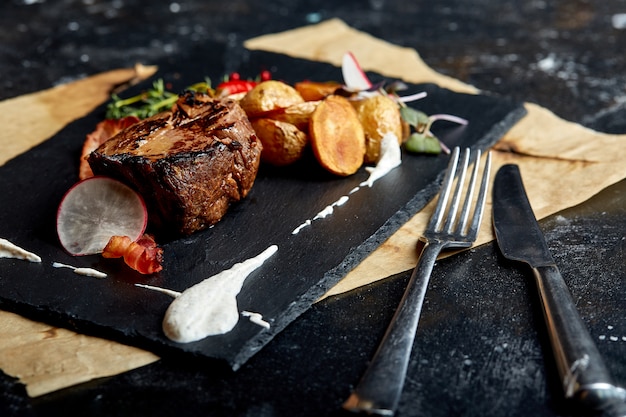 Comida de conceito. bife com mini batatas, espaço em preto.