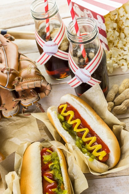 Comida de festa de beisebol com bolas e luva em uma mesa de madeira.