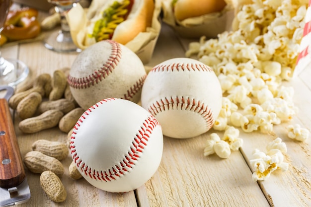 Foto comida de festa de beisebol com bolas e luva em uma mesa de madeira.