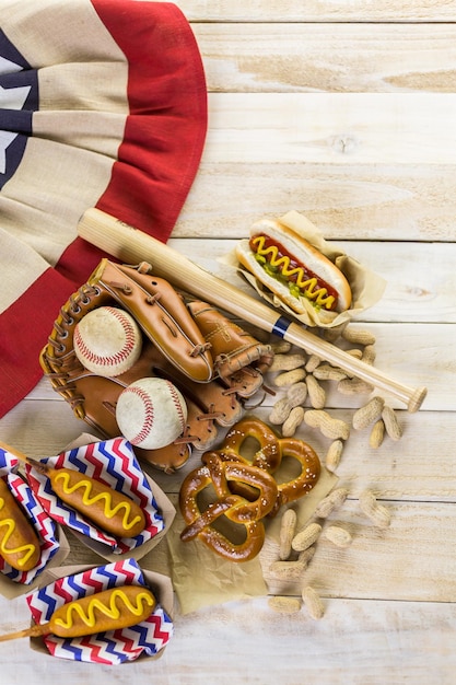 Comida de festa de beisebol com bolas e luva em uma mesa de madeira.